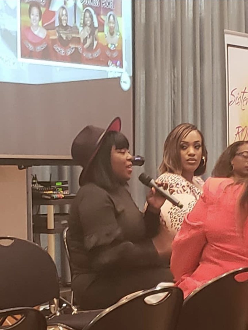 A speaker addressing attendees at a Sisterhood ROCKS event