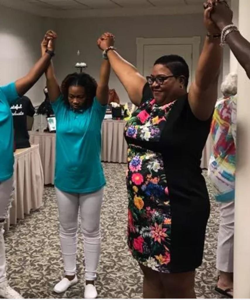 Women standing together with raised hands at an event