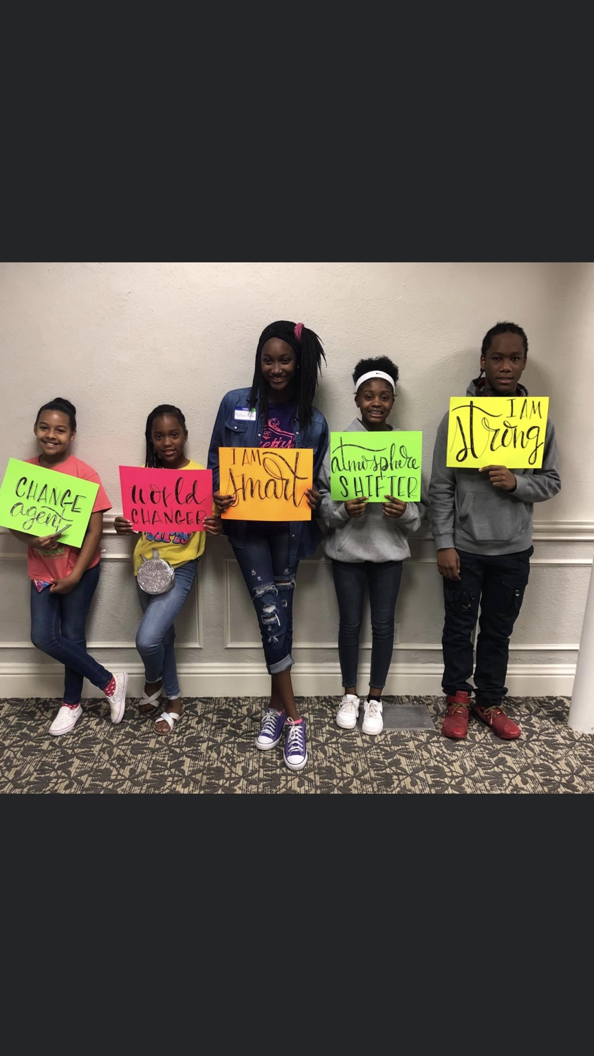 Young people holding colorful affirmation signs